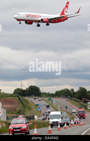 Air Berlin Flugzeug überquert die A45, Coventry Road vor der Landung am Flughafen Birmingham. Die Straße soll verschoben werden. Stockfoto