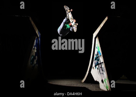 Ein Skateboarder Reiten eine Quarterpipe mit einem Indy grab Trick. Dieser Schuss wurde in der Nacht mit zwei Blitzen getroffen. Stockfoto