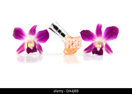 Die lila Orchidee und Orange Parfüm-Flaschen auf dem weißen Hintergrund. Stockfoto