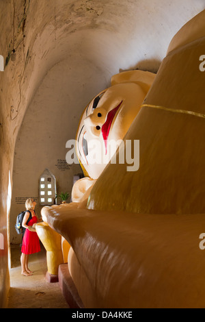 Riesigen liegenden Buddha mit touristischen Frau am Manuha Paya in Bagan, Birma Stockfoto