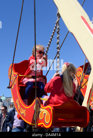 Kinder freuen sich über eine Schiffsschaukel auf der Kirmes Stockfoto