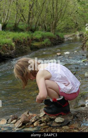 Mädchen hocken unten am Bach Stockfoto