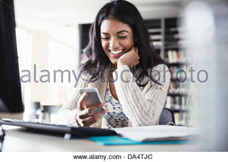 Studentin mit Smartphone in der Universitätsbibliothek