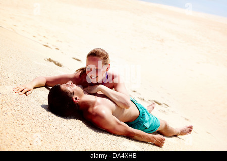 Foto von hübschen Frau betrachten ihr Ehemann beide liegend auf sand Stockfoto