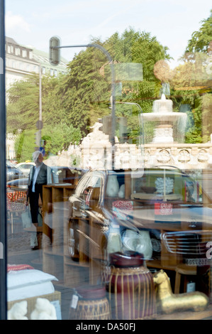 Schaufenster in der Nähe Lenbachplatz, München mit Wittelsbacher Brunnen im Hintergrund, Bayern, Deutschland Stockfoto