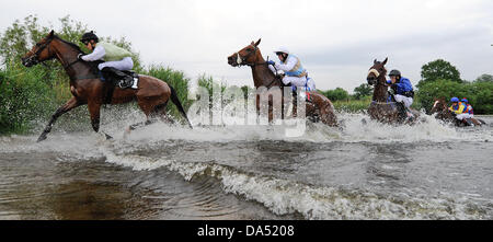 Hamburg, Deutschland. 3. Juli 2013. Pferde und Reiter überqueren eine Wasser-Hürde im See Jagd Rennen (Seejagdrennen) im Pferdesport Galopp Derby Meeting auf der Rennbahn Hamburg Horn in Hamburg, Deutschland, 3. Juli 2013. Foto: AXEL HEIMKEN/Dpa/Alamy Live News Stockfoto