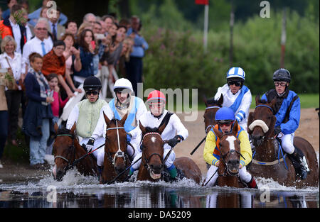 Hamburg, Deutschland. 3. Juli 2013. Pferde und Reiter überqueren eine Wasser-Hürde im See Jagd Rennen (Seejagdrennen) im Pferdesport Galopp Derby Meeting auf der Rennbahn Hamburg Horn in Hamburg, Deutschland, 3. Juli 2013. Foto: AXEL HEIMKEN/Dpa/Alamy Live News Stockfoto