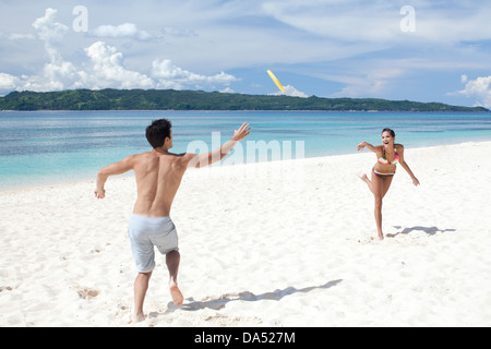 Ein junges Paar am Strand spielen. Stockfoto