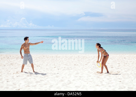 Ein junges Paar am Strand spielen. Stockfoto