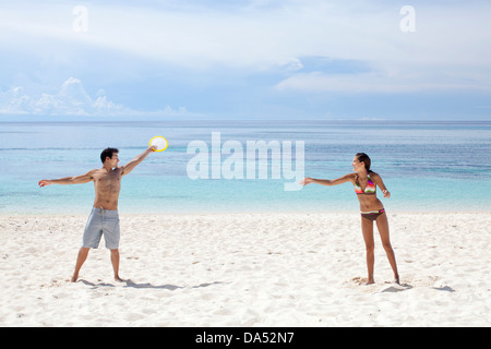 Ein junges Paar am Strand spielen. Stockfoto