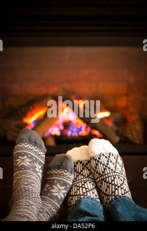 Füße in Wollsocken Erwärmung durch gemütliches Feuer Stockfoto