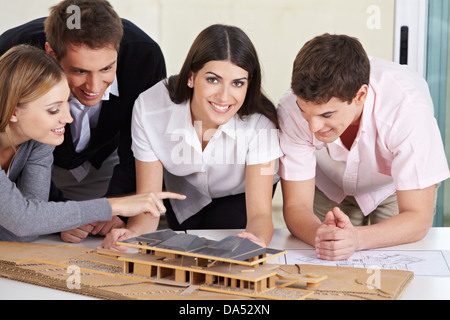Vier Architekten diskutieren eine 3D Haus Entwurf in ihrem Büro Stockfoto