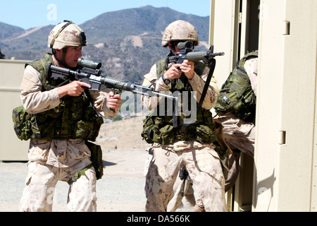 Canadian Army Infanteristen mit dem Royal 22. Regiment bieten Sicherheit, da der Rest des Teams eine Tür in einer Stadt mit Ausbildung in Camp Pendleton, Kalifornien, 17. Juni 2013, im Jahr 2013 Dawn Blitz verletzt. Die Soldaten zeigte ihre städtischen Handlungskompetenzen zu US-Marines mit dem 1. Bataillon, 1. Marine Regiment, da sie gelöscht und zweistöckigen Gebäuden, Treppen und Gassen in der ganzen Stadt. Dawn-Blitz ist eine multilaterale amphibische Übung entwickelt, um die Fähigkeiten von der US Navy und Marine Corps sowie mehrere Partnernationen zu stärken. Stockfoto