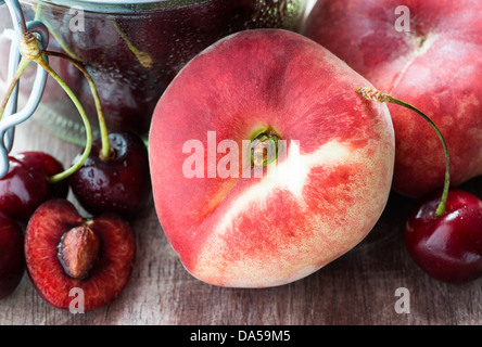 Donut Pfirsiche und Kirschen über hölzerne Hintergrund, Nahaufnahme, selektiven Fokus Stockfoto