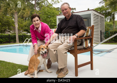 Erfolgreiche Reife paar stellt durch ihren Swimmingpool, USA Stockfoto