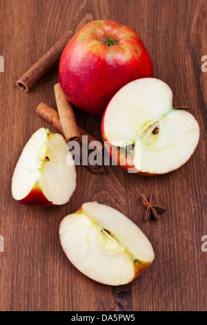 Ganze und geschnittene rote reife Äpfel auf hölzernen Hintergrund Stockfoto