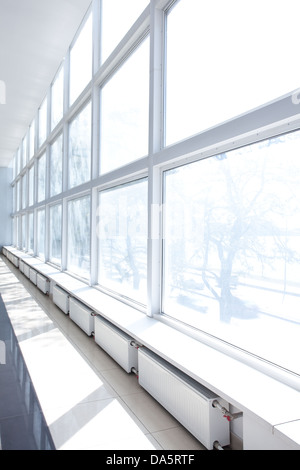 Leeren Raum mit großen weißen Fenstern und Heizkörpern Stockfoto