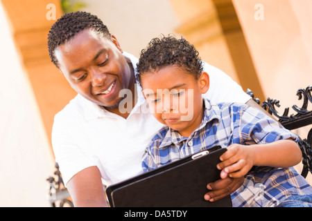 Glückliche afrikanischen amerikanischen Vater und Mischlinge Sohn haben Spaß mit Touch Pad Computer Tablet vor. Stockfoto