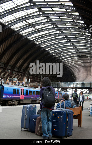 Tourist-Pendler mit mehreren Koffern wartet auf Schiene Transportmain-Linie Bahnhof in der Stadt von York, Yorkshire, Stockfoto