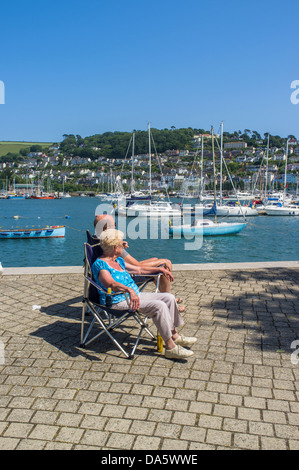 Dartmouth, Devon, England. 1. Juli 2013. Ehepaar im Ruhestand genießen Sie die Sonne durch den Fluss und den Blick auf Kingswear. Stockfoto