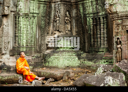 Mönch sitzt in einem alten Tempel mit Schnitzereien Stockfoto