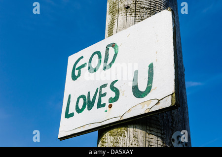 Anmelden eines Lampost mit handgeschriebenen Nachricht "Gott liebt U", typisch für viele Zeichen im ländlichen Teilen Nordirlands Stockfoto