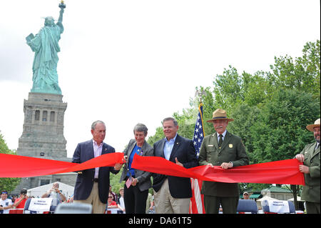 New York, USA. 4. Juli 2013. Minister fuer dem inneren Sally Jewell geschnitten auf 4. Juli 2013 ein Band um die Freiheitsstatue symbolisch wieder zu öffnen, nach Liberty Island seit acht Monaten wegen Schäden durch Hurrikan Sandy geschlossen worden war. Begleitet wurde sie von New Yorks Bürgermeister Michael Bloomberg, New Jersey Senator Bob Menendez und Jonathan Jarvis, der Direktor des National Park Service. Bildnachweis: Terese Loeb Kreuzer/Alamy Live-Nachrichten Stockfoto