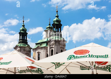 Die Türme und die Kuppel der St.-Nikolaus-Kirche in der Altstädter Ring, Prag-Turm über den Sonnenschirmen eine Bar im Freien. Stockfoto