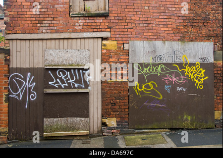 Geschändeter Graffiti bedeckt verfallenen Garage auf hintere Gasse in Leeds West Yorkshire England UK Stockfoto