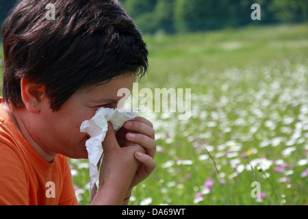 Kind mit einer Allergie gegen Pollen, während Sie die Nase mit einem weißen Taschentuch schneuzen Stockfoto