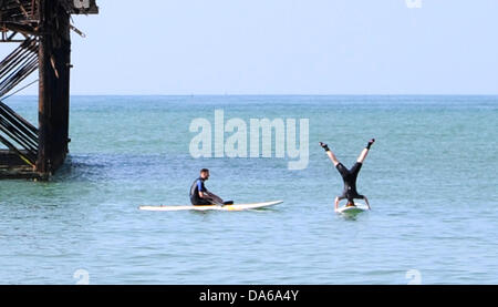 Brighton UK 5. Juli 2013 - die Hitzewelle beginnt hier zu zweit am frühen Morgen Paddel Boarder von ihnen selbst verwalten, Handstand zu tun, wie sie das heiße Wetter von der West Pier Brighton heute genießen.  Foto von Simon Dack/Alamy Live News Stockfoto