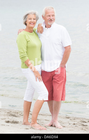 Gerne älteres paar stehen am Strand Stockfoto