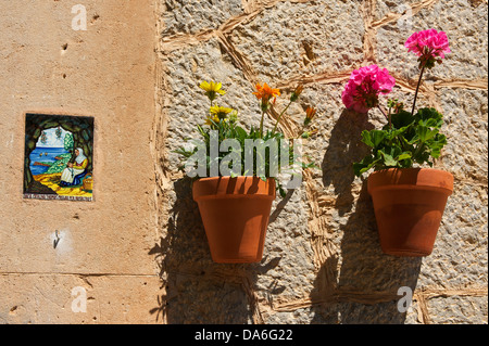 Heilige Bild und Blumentöpfe auf einer Hauswand Stockfoto