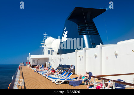 Oman, Maskat, Sonnenanbeter auf dem Promenadendeck Sonnenliegen in Sonne Stockfoto