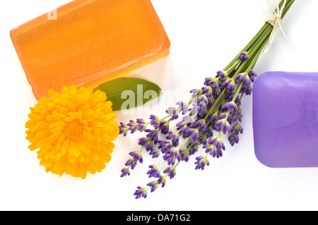 Handgemachte Glyzerin Seifen mit Blumen auf weißem Hintergrund. Natürliche Schönheitspflege - Lavendel und Ringelblume (Calendula Officinalis). Stockfoto