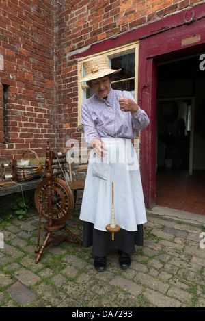 Shropshire. Acton Scott Historic working Farm. Viktorianische kostümierte Frau Spinnen auf einer Hand Spindel. England, Großbritannien Stockfoto