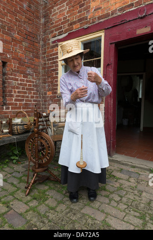 Shropshire. Acton Scott Historic working Farm. Viktorianische kostümierte Frau Spinnen auf einer Hand Spindel. England, Großbritannien Stockfoto