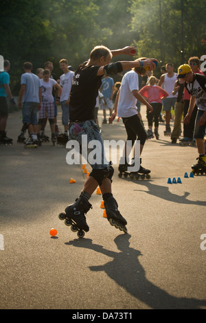 Mann-Inline-Skating durch Slalom Kegel Stockfoto