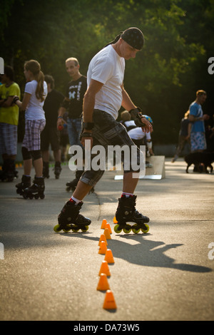 Mann-Inline-Skating durch Slalom Kegel Stockfoto