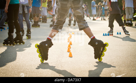 Mann-Inline-Skating durch Slalom Kegel Stockfoto