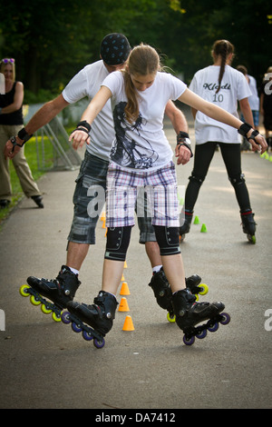 Paar synchron Inlineskating durch Slalom Zapfen. Stockfoto