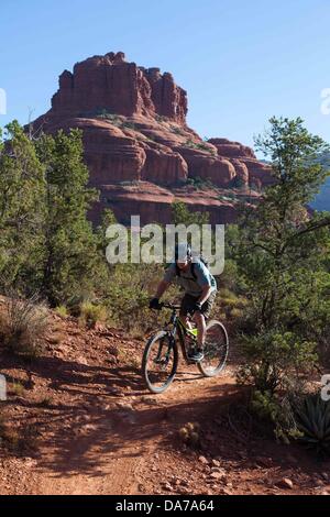 9. Juni 2013 - Sedona, Arizona, USA - Fahrradtouren Mountainbiker seine auf roten Slickrock unten hoch aufragende Kuppen auf dem HiLine Trail in Sedona. Sedona Hauptattraktion ist eine Reihe von roten Sandstein-Formationen, die zu glühen in leuchtende Orange und rot, wenn der Aszendent oder untergehende Sonne beleuchtet erscheinen. Die roten Felsen bilden eine beliebte Kulisse für zahlreiche outdoor-Aktivitäten von spirituellen Bestrebungen bis hin zu den Hunderten von Wander- und Mountainbike-Strecken. Sedona war benannt nach Sedona Arabelle Miller Schnebly (1877âˆ "1950), die Ehefrau von Theodore Carlton Schnebly, die Stadt erste Postmeister. (Cred Stockfoto