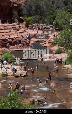 9. Juni 2013 - Sedona, Arizona, USA - Besucher genießen das kühle Wasser von einem überfüllten Slide Rock State Park in Sedona. Sedona Hauptattraktion ist eine Reihe von roten Sandstein-Formationen, die zu glühen in leuchtende Orange und rot, wenn der Aszendent oder untergehende Sonne beleuchtet erscheinen. Die roten Felsen bilden eine beliebte Kulisse für zahlreiche outdoor-Aktivitäten von spirituellen Bestrebungen bis hin zu den Hunderten von Wander- und Mountainbike-Strecken. Sedona war benannt nach Sedona Arabelle Miller Schnebly (1877âˆ "1950), die Ehefrau von Theodore Carlton Schnebly, die Stadt erste Postmeister. (Bild Kredit: Â © Ruaridh Eintopf Stockfoto