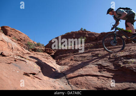 9. Juni 2013 - Sedona, Arizona, USA - Fahrradtouren Mountainbiker seine auf roten Slickrock HiLine unterwegs in Sedona. Sedona Hauptattraktion ist eine Reihe von roten Sandstein-Formationen, die zu glühen in leuchtende Orange und rot, wenn der Aszendent oder untergehende Sonne beleuchtet erscheinen. Die roten Felsen bilden eine beliebte Kulisse für zahlreiche outdoor-Aktivitäten von spirituellen Bestrebungen bis hin zu den Hunderten von Wander- und Mountainbike-Strecken. Sedona ist benannt nach Sedona Arabelle Miller Schnebly (1877−1950), die Ehefrau von Theodore Carlton Schnebly, die Stadt erste Postmeister. (Kredit-Bild: © Ruaridh Eintopf Stockfoto