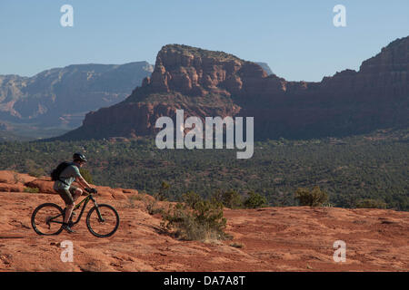 9. Juni 2013 - Sedona, Arizona, USA - Fahrradtouren Mountainbiker seine auf roten Slickrock HiLine unterwegs in Sedona. Sedona Hauptattraktion ist eine Reihe von roten Sandstein-Formationen, die zu glühen in leuchtende Orange und rot, wenn der Aszendent oder untergehende Sonne beleuchtet erscheinen. Die roten Felsen bilden eine beliebte Kulisse für zahlreiche outdoor-Aktivitäten von spirituellen Bestrebungen bis hin zu den Hunderten von Wander- und Mountainbike-Strecken. Sedona ist benannt nach Sedona Arabelle Miller Schnebly (1877−1950), die Ehefrau von Theodore Carlton Schnebly, die Stadt erste Postmeister. (Kredit-Bild: © Ruaridh Eintopf Stockfoto