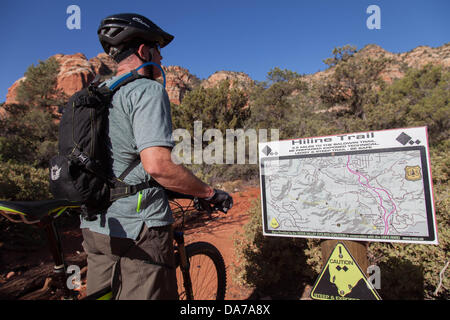 9. Juni 2013 - Sedona, Arizona, USA - fährt Überprüfung der Karte ein Mountainbiker Rad auf roten Slickrock HiLine unterwegs in Sedona. Sedona Hauptattraktion ist eine Reihe von roten Sandstein-Formationen, die zu glühen in leuchtende Orange und rot, wenn der Aszendent oder untergehende Sonne beleuchtet erscheinen. Die roten Felsen bilden eine beliebte Kulisse für zahlreiche outdoor-Aktivitäten von spirituellen Bestrebungen bis hin zu den Hunderten von Wander- und Mountainbike-Strecken. Sedona ist benannt nach Sedona Arabelle Miller Schnebly (1877−1950), die Ehefrau von Theodore Carlton Schnebly, die Stadt erste Postmeister. (Kredit Ima Stockfoto