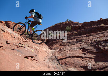 9. Juni 2013 - Sedona, Arizona, USA - Fahrradtouren Mountainbiker seine auf roten Slickrock HiLine unterwegs in Sedona. Sedona Hauptattraktion ist eine Reihe von roten Sandstein-Formationen, die zu glühen in leuchtende Orange und rot, wenn der Aszendent oder untergehende Sonne beleuchtet erscheinen. Die roten Felsen bilden eine beliebte Kulisse für zahlreiche outdoor-Aktivitäten von spirituellen Bestrebungen bis hin zu den Hunderten von Wander- und Mountainbike-Strecken. Sedona ist benannt nach Sedona Arabelle Miller Schnebly (1877−1950), die Ehefrau von Theodore Carlton Schnebly, die Stadt erste Postmeister. (Kredit-Bild: © Ruaridh Eintopf Stockfoto