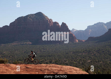 9. Juni 2013 - Sedona, Arizona, USA - Fahrradtouren Mountainbiker seine auf roten Slickrock HiLine unterwegs in Sedona. Sedona Hauptattraktion ist eine Reihe von roten Sandstein-Formationen, die zu glühen in leuchtende Orange und rot, wenn der Aszendent oder untergehende Sonne beleuchtet erscheinen. Die roten Felsen bilden eine beliebte Kulisse für zahlreiche outdoor-Aktivitäten von spirituellen Bestrebungen bis hin zu den Hunderten von Wander- und Mountainbike-Strecken. Sedona ist benannt nach Sedona Arabelle Miller Schnebly (1877−1950), die Ehefrau von Theodore Carlton Schnebly, die Stadt erste Postmeister. (Kredit-Bild: © Ruaridh Eintopf Stockfoto