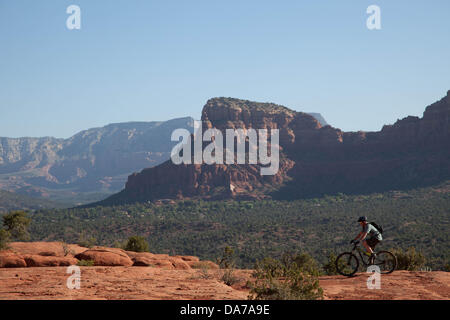 9. Juni 2013 - Sedona, Arizona, USA - Fahrradtouren Mountainbiker seine auf roten Slickrock HiLine unterwegs in Sedona. Sedona Hauptattraktion ist eine Reihe von roten Sandstein-Formationen, die zu glühen in leuchtende Orange und rot, wenn der Aszendent oder untergehende Sonne beleuchtet erscheinen. Die roten Felsen bilden eine beliebte Kulisse für zahlreiche outdoor-Aktivitäten von spirituellen Bestrebungen bis hin zu den Hunderten von Wander- und Mountainbike-Strecken. Sedona ist benannt nach Sedona Arabelle Miller Schnebly (1877−1950), die Ehefrau von Theodore Carlton Schnebly, die Stadt erste Postmeister. (Kredit-Bild: © Ruaridh Eintopf Stockfoto