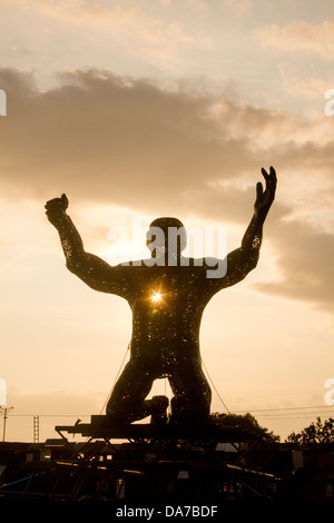 Statue von einem riesigen Mann auf die Knie in der Arena Silber Hayes, Glastonbury Festival 2013 Stockfoto